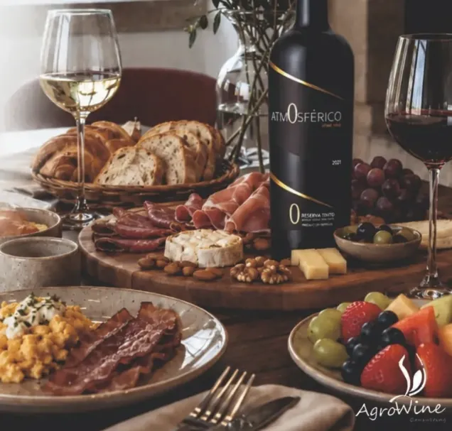 Mesa de brunch com pão, enchidos, queijo, ovos mexidos, fruta e vinho Atmosférico